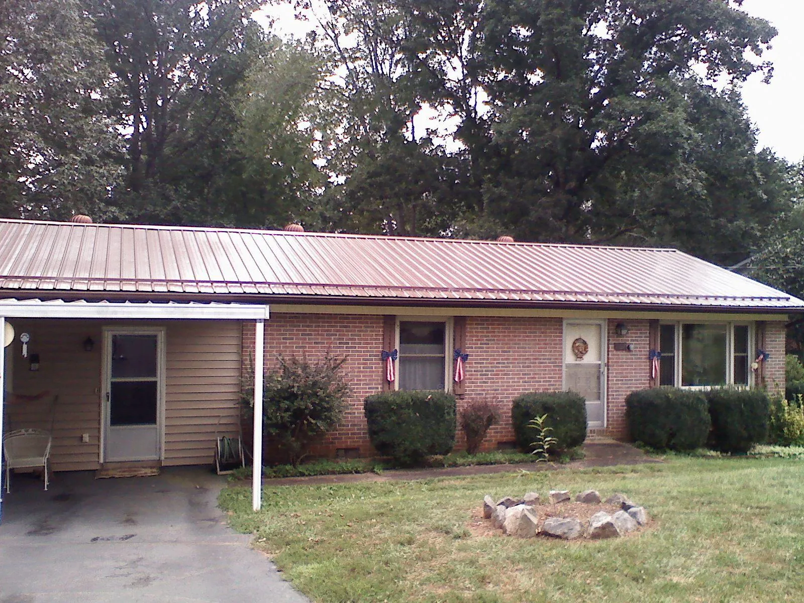 Bronze metal roof and carport on a brick ranch home — Roof Repair work by our crew in Manchester